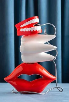 Creative still life with lips, teeth and jaw on blue velvet background. Den.. Stock Photos