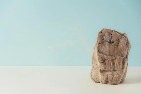 Creative stone podium for cosmetics or products on blue background. Stock Photos