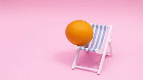 Creative stop motion animation of sun lounger with fresh orange and umbrella Stockbeeldmateriaal 158873798