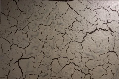 Creative structure with a cracked surface on a dark background. Stock Photos