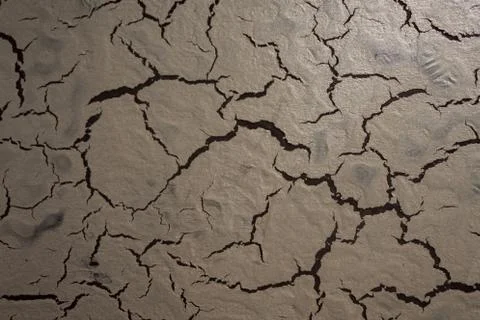 Creative structure with a cracked surface on a dark background. Stock Photos