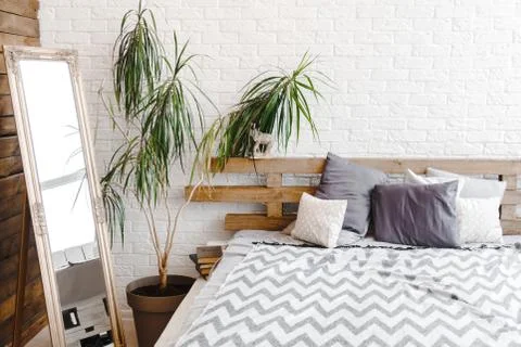 Creative studio decor design with pallets bed, plant in vase and books Stock Photos