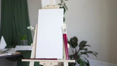 Creative studio. Empty white canvas on a wooden easel and red brushes Stock Footage 156937934