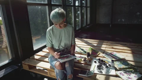 Creative studio of a modern artist: she paints with paint and brush. Stock-Footage 94808086