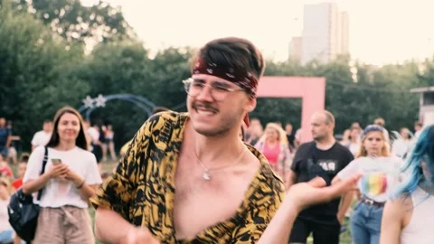 Creative stylish guy dances at street music festival looking into the camera. 動画素材 204795697