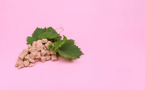 Creative The sugar content of grapes. Bunch of grapes made of sugar on a pink Stock Photos