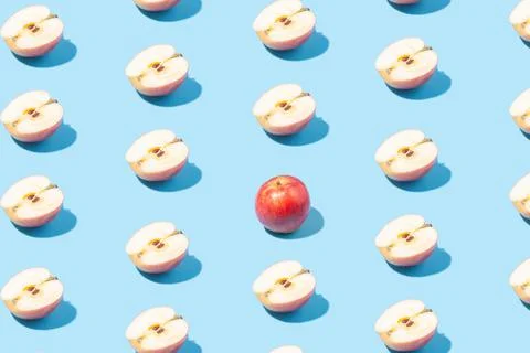 Creative summer background of apple halves on a blue background. Minimal summ Stock Photos