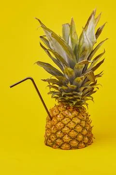 A creative summer composition with a pineapple and a cocktail tube. The conce Stock Photos
