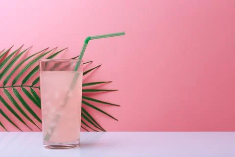 Creative summer composition with pink drink with straw on white table against Stock Photos