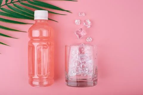 Creative summer composition with pink lemonade in a bottle and glass with Stock Photos