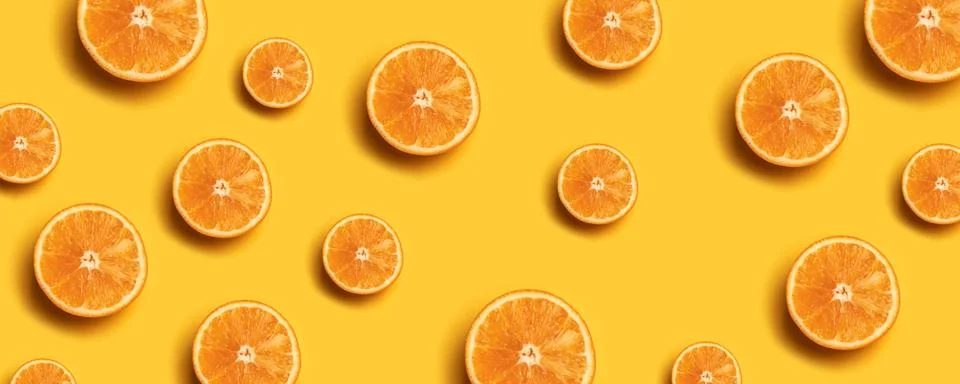 Creative summer pattern made of fresh orange slices on yellow background. 스톡 사진