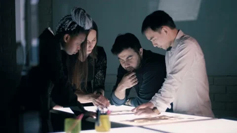 Creative team of architects of different nationalities is working at night on a Stock Footage 135297559