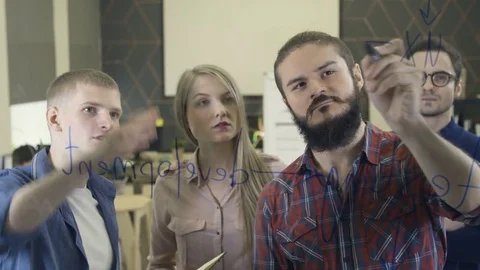 Creative team brainstorming and writing on glass Stock Footage 72548767