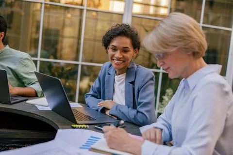 Creative team collaborating on project during meeting in outdoor cafe Stock Photos