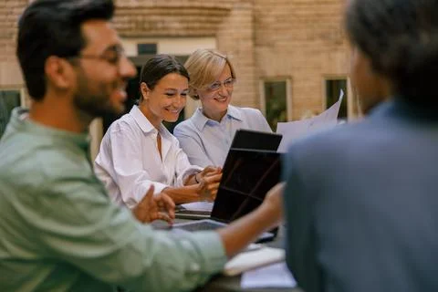 Creative team collaborating on project during meeting in outdoor cafe Stock Photos
