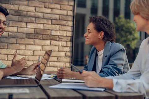 Creative team collaborating on project during meeting in outdoor cafe Stock Photos