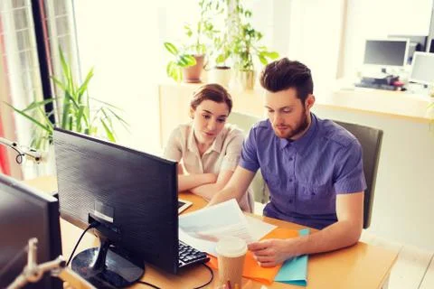 Creative team with computer and papers in office Stock Photos