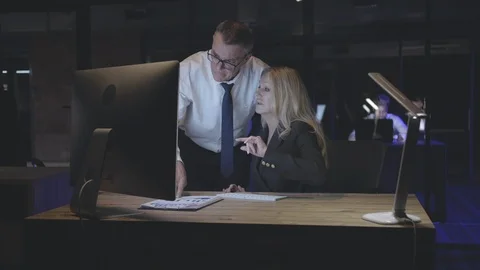Creative team with computer computer working together late at night office Stock Footage 125683473
