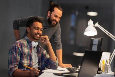 Creative team with computer working late at office Foto stock