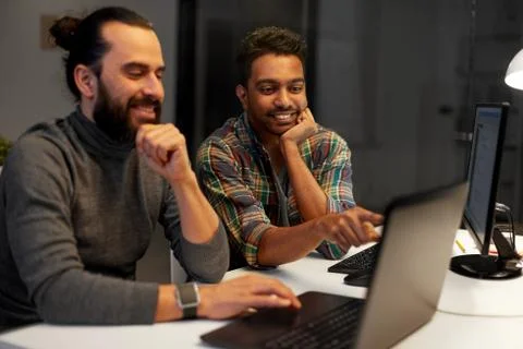 Creative team with computer working late at office Stock Photos