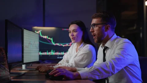 Creative team of cryptocurrency traders celebrating successful trading while Stock Footage 266464557