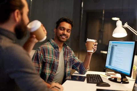 Creative team drinking coffee at night office Stock Photos