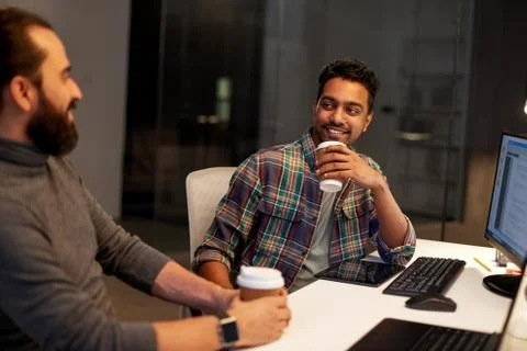 Creative team drinking coffee at night office Stock Photos