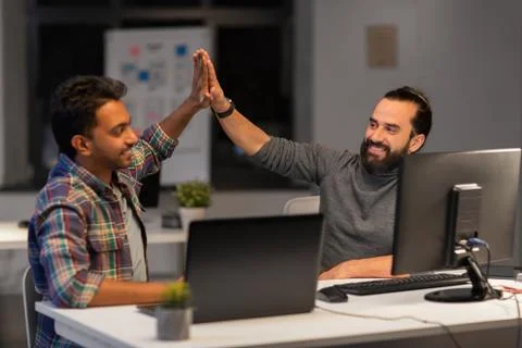 Creative team making high five at night office Stock Photos