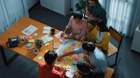 Creative team making scrum task board while using sticky note. Convocation. Stock Photos