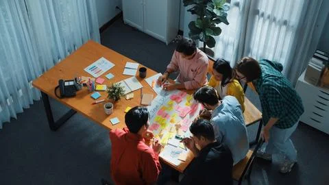Creative team making scrum task board while using sticky note. Convocation. 库存照片