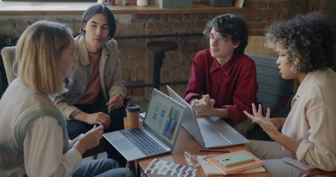Creative team mobile app developers talking looking at laptop screen working in Video stock 274265224