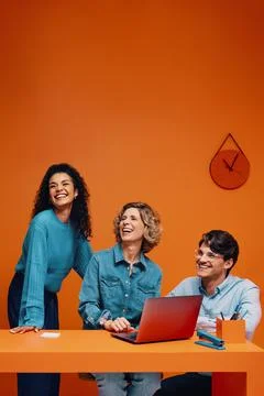Creative team in monochromatic orange set with colorblocking elements Stock Photos