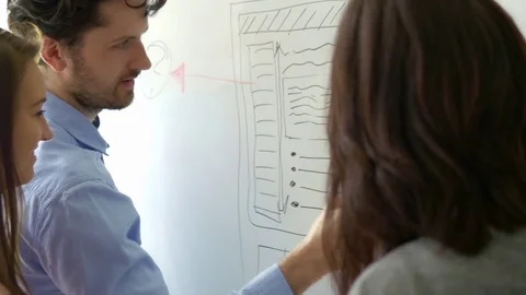Creative team sketching on the whiteboard at the office Stock Footage 75556528