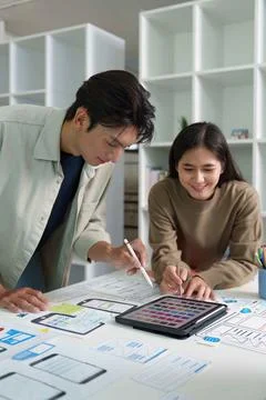 Creative Teamwork. Young designers collaborating on digital mockups and color Stock Photos