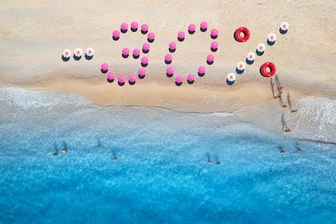 Creative text -30 made from umbrellas on sandy beach, blue sea Foto stock