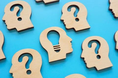 Creative thinking and problem solving. Heads with question marks and a light Stockfoto's
