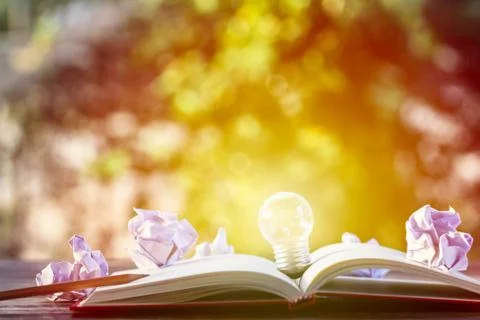 Creative thinking, idea, business concept : Light bulb put on open notebook w Stock Photos