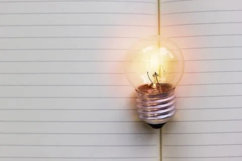 Creative thinking, idea, business concept : Light bulb put on open notebook w Stock Photos