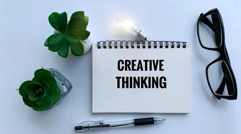 Creative thinking text on notepad with light bulb, glasses, pen and plant Stock Photos