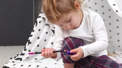 Creative toddler exploring colors in a cozy indoor fort during playtime Video stock 295353804