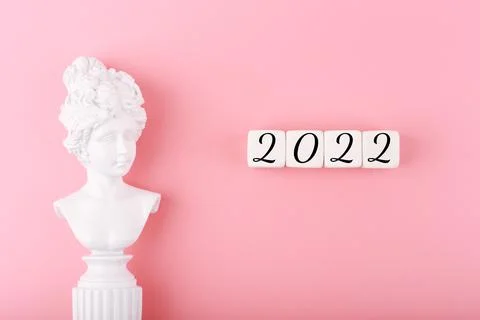 Creative trendy 2022 concept. Numbers written on white cubes next to white Stock Photos