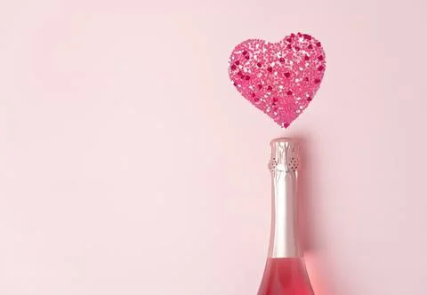Creative trendy flat lay with pink heart shaped confetti poured out of champagne Stock Photos