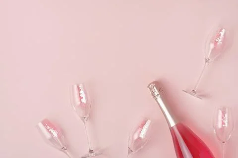 Creative trendy flat lay with pink champagne bottle and flutes filled with pink Stock Photos