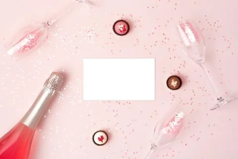 Creative trendy flat lay with pink champagne bottle, flutes and isolated white Stock Photos