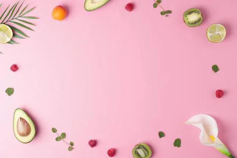 Creative tropical background made from fresh fruits and palm leaves on pink.  Stock Photos