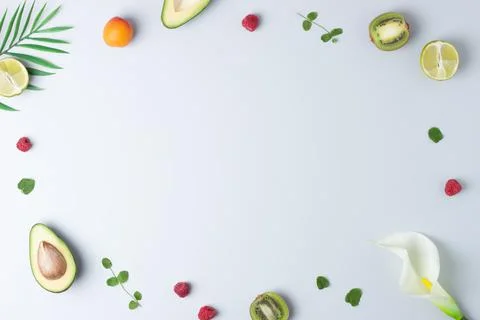 Creative tropical background made from fresh fruits and palm leaves on grey.  Foto stock
