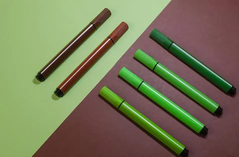 Creative two-color composition with green and brown felt-tip pens. Stock Photos