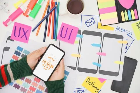 Creative UX UI designer hand holding mobile white screen mockup at working de Stock Photos