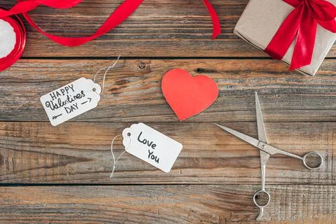 Creative Valentine's Day background with gift tags and box, top view. Stock Photos