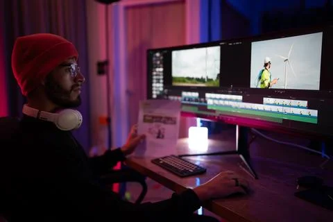 Creative video editor working late at night on a dual monitor setup in a di.. Stock Photos